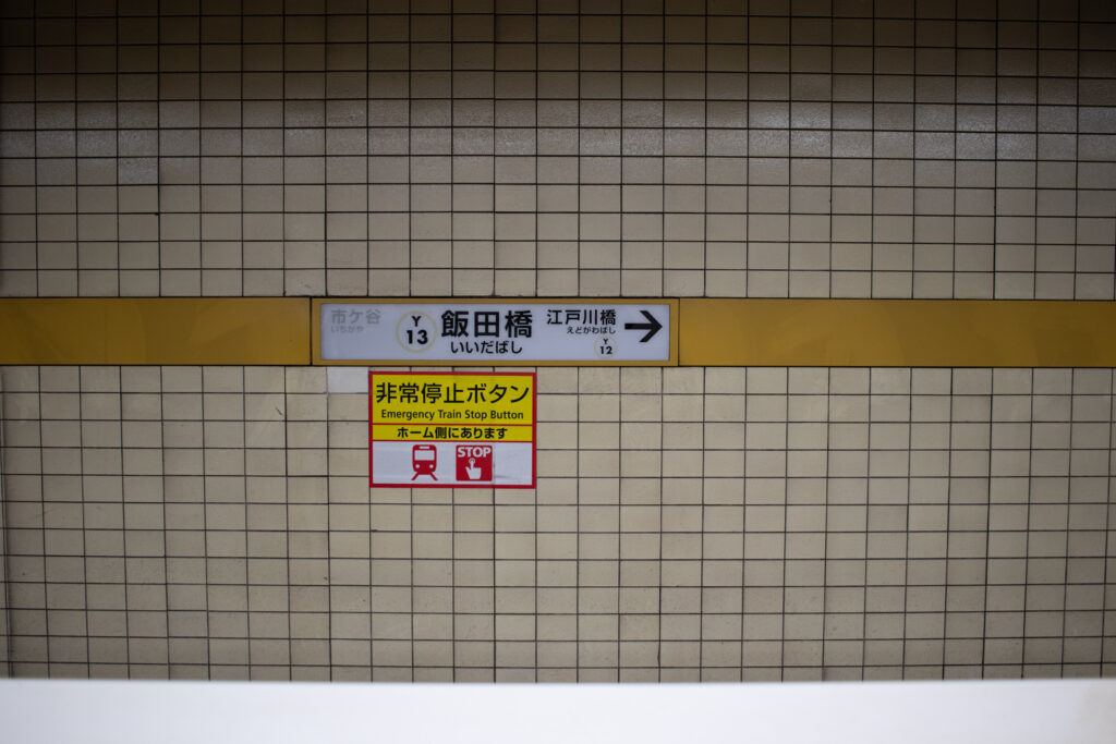 a photograph of a sign indicating Iidabashi Station in Tokyo, Japan