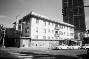 a black and white photograph of a building in Oakland, California. One side of the building is reflecting sunlight, while the other side sits in shadow.